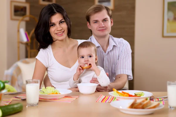 Young family at home having meal — Stock Photo, Image