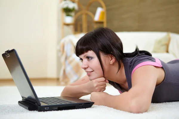 Giovane donna con un computer portatile a casa — Foto Stock