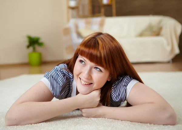 Jong meisje thuis ontspannen op het tapijt — Stockfoto