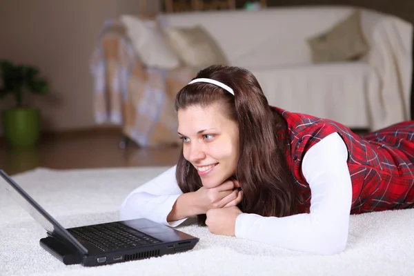 Une jeune fille avec un ordinateur portable à la maison — Photo