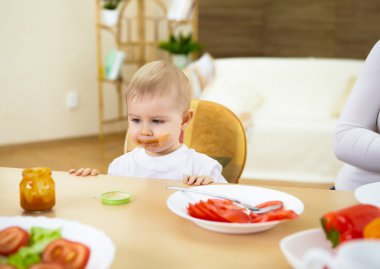 küçük bebek evde masada oturma ve yemek olan