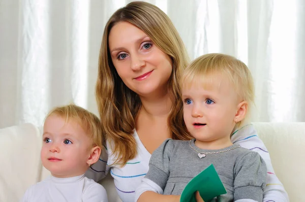 Junge Mutter Mit Ihren Beiden Zwillingstöchtern Auf Einem Sofa Sitzend — Stockfoto