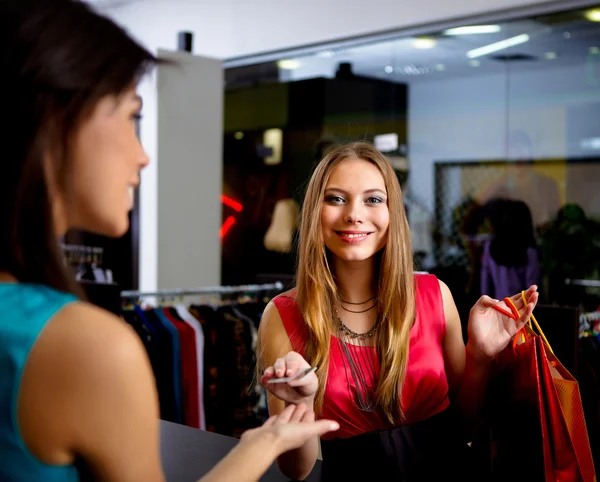 Jonge vrouw in een winkel kleding kopen — Stockfoto