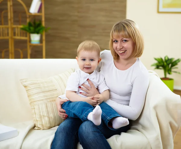 小さな男の子と若い母親一緒に自宅でソファに座って — ストック写真