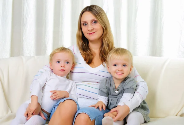 Jovem Mãe Com Suas Duas Filhas Gêmeas Sentadas Sofá — Fotografia de Stock