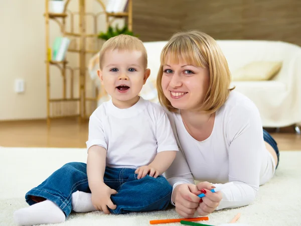 年轻的母亲和她的小儿子在家里用彩色铅笔绘图 — 图库照片
