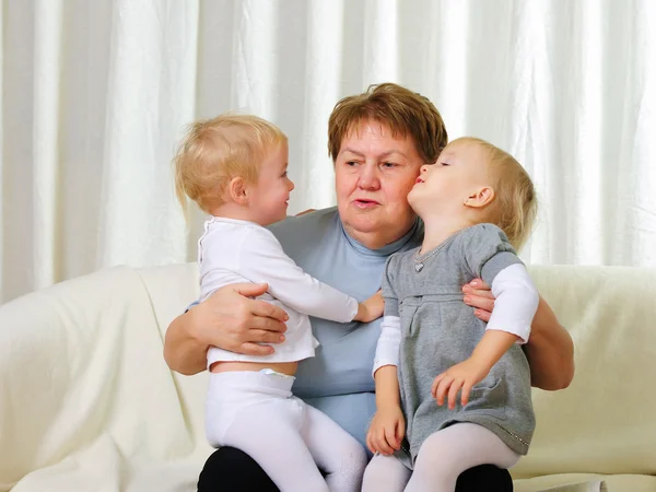 Two twins sisters with their grandmother — Stock Photo, Image