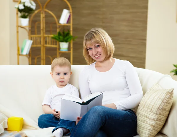 Mały chłopiec i jego matkę w domu czytając książkę — Zdjęcie stockowe