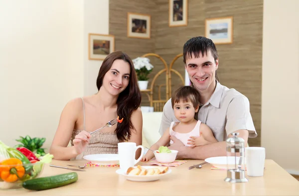 Молодая семья дома обедает — стоковое фото