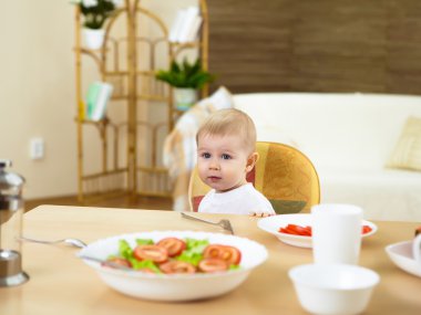 küçük bebek evde masada oturma ve yemek olan