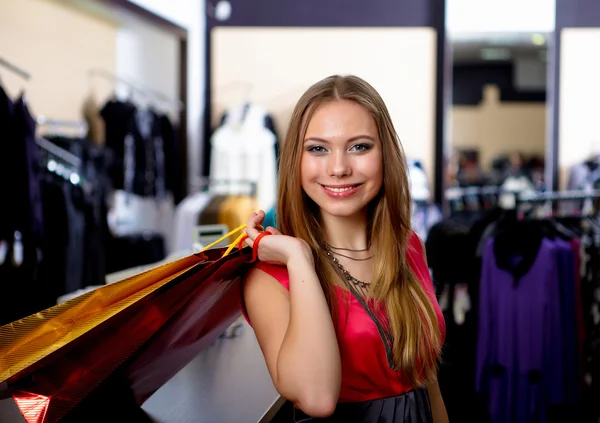 Mujer joven en una tienda comprando ropa — Foto de Stock