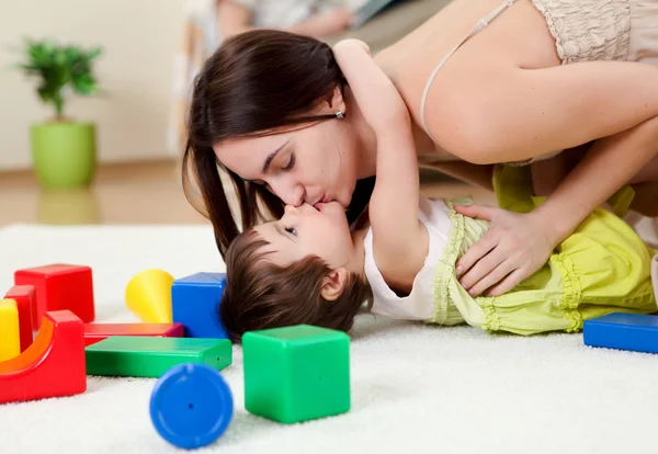 Joven madre jugando con su bebé en casa —  Fotos de Stock