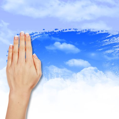 Hand wipes misted window at a blue sky clipart