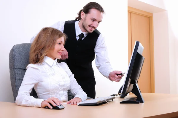 一个年轻的商人和一个女孩在办公室的计算机上运行 — 图库照片