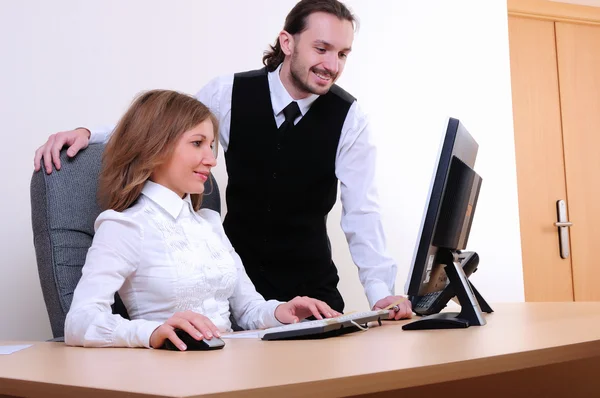 一个年轻的商人和一个女孩在办公室的计算机上运行 — 图库照片