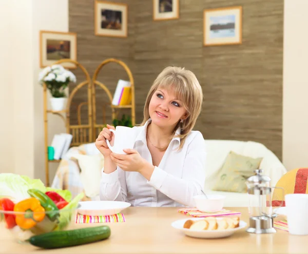 Jovem mulher tendo refeição em casa — Fotografia de Stock