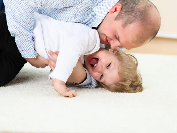 Far och son spelar på golvet hemma — Stockfoto