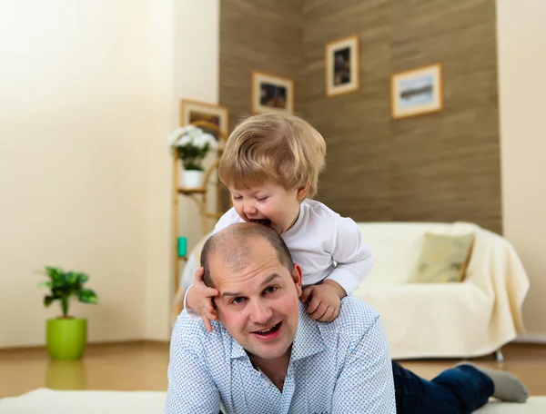 Pai e filho brincando no chão em casa — Fotografia de Stock
