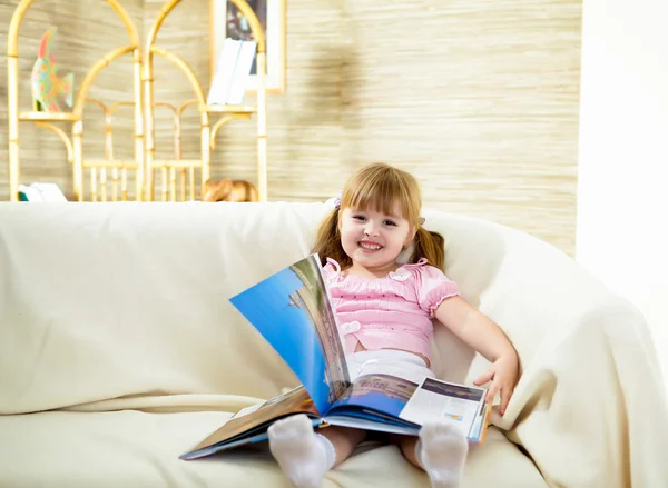 Happy Smiling Little Girl Sitting Sofa Reading Book — Stock Photo, Image