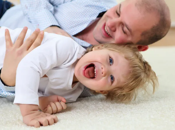 Father and son playing on the floor at home — Stock Photo, Image