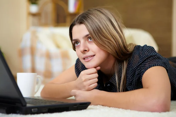 Jeune femme avec un ordinateur portable à la maison — Photo