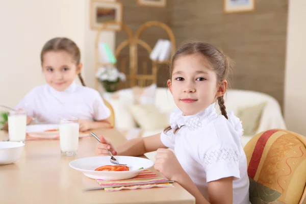 Een klein meisje thuis hebben maaltijd Stockfoto