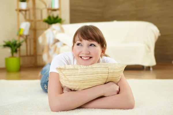 Молода жінка розслабляється вдома на підлозі — стокове фото