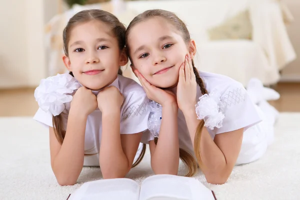 Twin sisters together at home with books — Stock Photo, Image