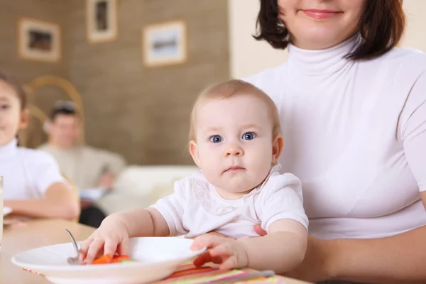 stock image A young mother feeding her infant baby at home