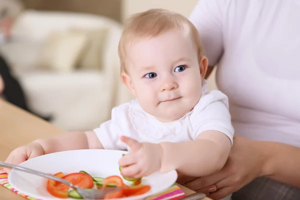 A young mother feeding her baby at home — Stock Photo, Image