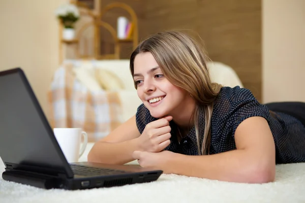Νεαρή γυναίκα με ένα φορητό υπολογιστή στο σπίτι — Φωτογραφία Αρχείου