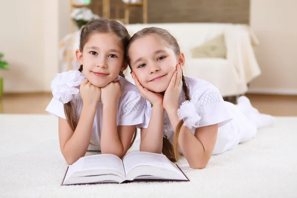 Dvojče sestry společně doma s knihami — Stock fotografie