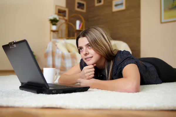 Молодая женщина с ноутбуком дома — стоковое фото