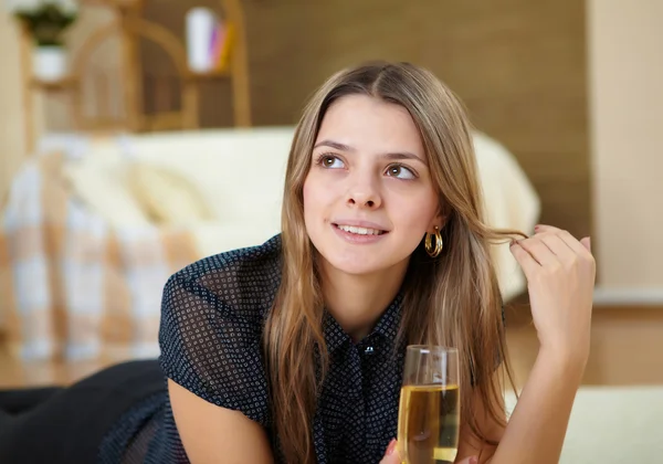 Молодая девушка пьет шампанское дома — стоковое фото