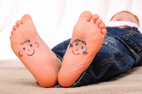 Small faces painted on the soles — Stock Photo, Image