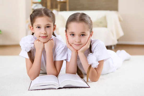 stock image Twin sisters together at home with books
