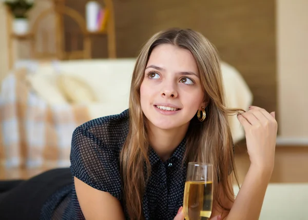 Mladá dívka pití šampaňského doma — Stock fotografie