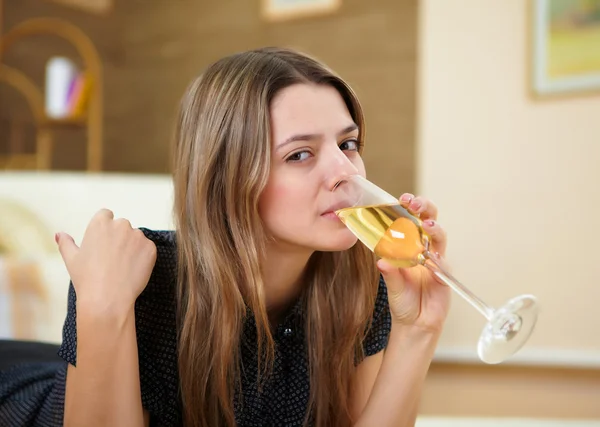 Genç kız evde şampanya içmek — Stok fotoğraf