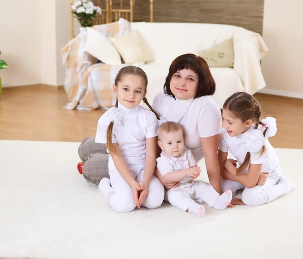 Молода мати з трьома доньками вдома — стокове фото
