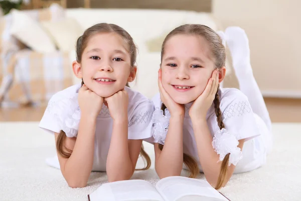 Twin sisters together at home with books — Stock Photo, Image