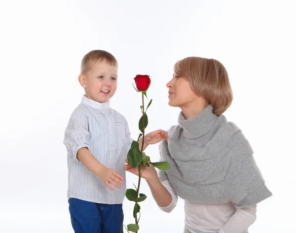 Madre e hijo sosteniendo una rosa roja — Foto de Stock