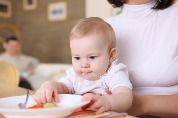 Eine junge Mutter füttert ihr Baby zu Hause — Stockfoto