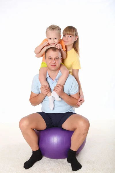 Family with a little daughter doing sport together — Stock Photo, Image