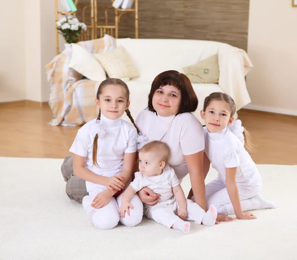 Una joven madre con sus tres hijas en casa — Foto de Stock