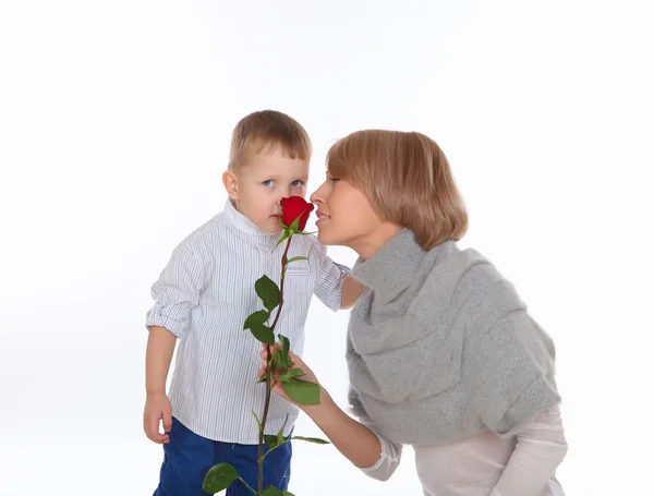 Madre e hijo sosteniendo una rosa roja —  Fotos de Stock