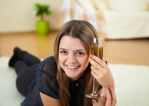 Молодая девушка пьет шампанское дома — стоковое фото