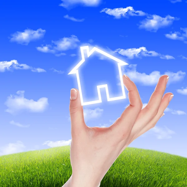 Hus i händerna mot den blå himlen — Stockfoto