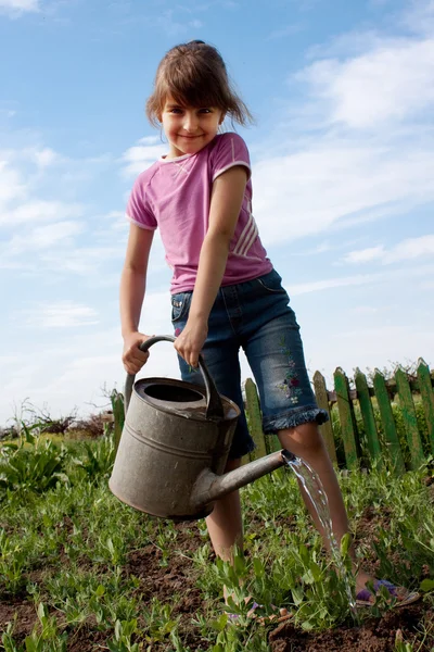 Маленькая девочка с лейкой банкой — стоковое фото