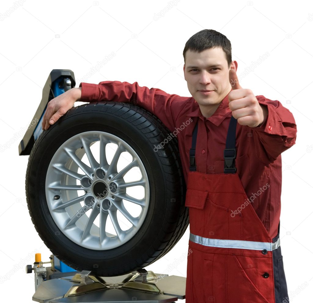 Handsome young car mechanic with wheel
