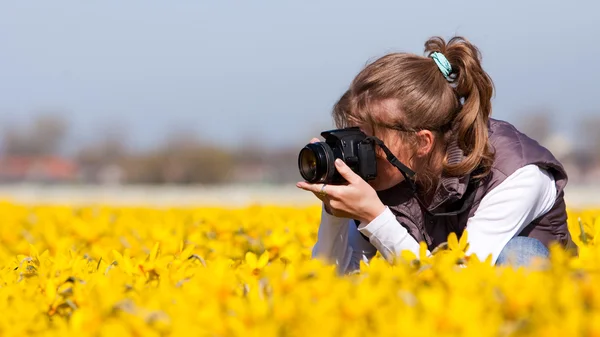 Menina fazendo fotos de flores — Fotografia de Stock